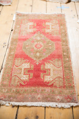 Faded cherry red and pale bronze-brown decorative motifs on the Oushak rug end.