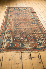 Antique Caucasian rug geometric border with oversized terra cotta, blue elements, and pile wear.