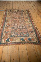 Antique Caucasian rug's geometric border in sky blue, terra cotta, beige, showing light tatter.