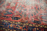 Worn red Lilihan rug pile, revealing navy, sky blue, and gold floral motifs.