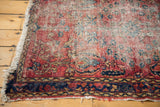 Classic Lilihan rug's fringed end, showing worn cherry red pile and dark navy border.