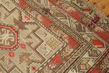 Geometric brick red and platinum patterns on an antique Caucasian rug, featuring a minor border patch.