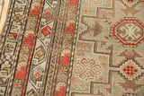 Geometric Caucasian rug field and border, featuring stylized blossoms in brick red and platinum.