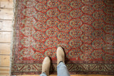 Vintage Hamadan rug displaying brick red boteh pattern, meandering vine border, and even wear.