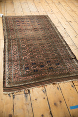 Vintage Belouch runner detail showing chocolate brown, blush pomegranate design, geometric border, and tatter.