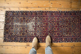 Vintage Yazd runner: hand knotted with allover navy, red floral design, and low pile wear.