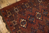 Hand-knotted low pile of vintage Turkmen rug, showing chestnut, navy, ivory gul motifs.