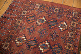 Repeating gul motifs in chestnut brown, dark navy, and ivory on a Vintage Chodor Turkmen rug.