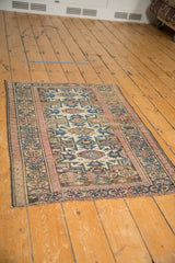 Caucasian vintage rug, geometric patterns in blush, cobalt blue, and beige.