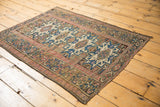 Vintage Caucasian rug lower corner, highlighting geometric cobalt blue patterns and a blush inner border.