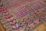 Fuchsia and dark navy geometric tent cover motif with visible wear on this antique Turkmen rug.