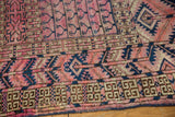 Fuchsia tent cover field and geometric navy, brown borders of the antique Turkmen rug, with wear.