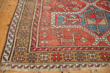Vintage Caucasian Avar rug corner with brown geometric border, red field, and secure fringe.