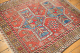 Geometric border and worn red field with motifs on the vintage Caucasian rug.