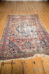 Antique Malayer rug: low pile, exposed foundation, faded red and navy patterns.