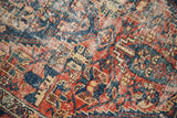 Worn pile featuring faded red and indigo floral cross-sections on an antique Malayer rug.