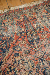 Antique Persian Malayer rug detail with wear to knot heads, showcasing faded cherry red and indigo patterns.