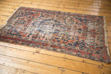 Antique Malayer rug corner detail, showing aged low pile and tattered fringe.