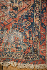Detail of worn pile, exposed foundation, and tattered fringe on the antique Malayer rug.