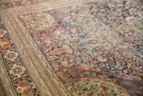 Detailed view of an antique Kermanshah carpet's fine weave, with scrolling arabesques and mostly even wear.