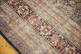 Angled view of the antique Kermanshah carpet's intricate floral borders with low, even pile.