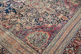 Low pile texture on an antique Kermanshah carpet, showing the scalloped corner and intricate borders.