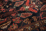 Hand-knotted Vintage Baktiari carpet, showing mostly even wear over navy and red floral design.