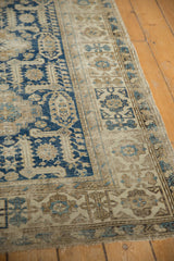 Detail of a traditional Caucasian Shirvan rug, showing navy blue geometric motifs and worn pile.