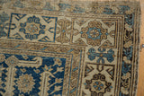 Corner detail of an antique Caucasian Shirvan rug with intricate navy, ivory, and sand geometric patterns.