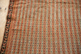 Close view of the antique Senneh rug's even wear showing detailed seed motifs in terra cotta stripes.