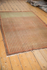 Antique Persian Senneh rug with intricate stripes, viewed from an angle to show its fine weave.