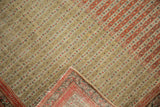 A folded corner of a fine antique Senneh rug reveals the hand-knotted foundation and weave.