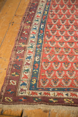 Late 19th-century Caucasian rug's worn madder red boteh field and geometric borders.