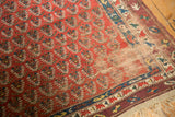 Antique Caucasian runner with exposed foundation, intricate macrame end, and geometric border.