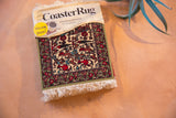 Packaged Variety CoasterRug with intricate Jade Fars pictorial design, red deer, and green border.
