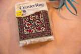 Pictorial CoasterRug with red animal and blue figure motifs, green border, and cream fringe.