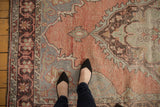 Close-up of distressed Oushak rug, highlighting blush and slate blue with visible foundation wear.