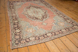 Distressed vintage Oushak carpet with mostly even wear across knot heads on muted blush and blue.