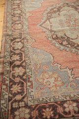 Vintage distressed Oushak rug border with charcoal geometric patterns, serrated blush field edge.