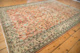 Distressed Oushak rug: apricot blush field with scrolling vinery and antique ivory border.