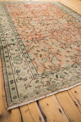 Distressed Oushak carpet corner, with ivory fringe, sea foam, and chocolate border.