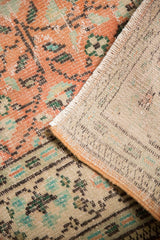 Vintage distressed Oushak rug, showing apricot pile with faint foundation and hand-knotted reverse.