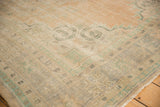 Distressed Oushak carpet's faded pile, with foundation visible and soft apricot, ivory, green patterns.