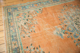 Distressed vintage Oushak rug with low pile, faded apricot, blue, and mint floral motifs.