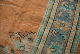 Visible knot heads and wear on distressed apricot Oushak pile and faded blue border.