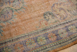 Vintage Distressed Oushak carpet's worn pile texture and pale royal blue, apricot border.