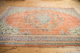 Vintage Distressed Oushak carpet with textured terracotta field, faded blue and green patterns.