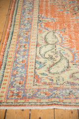 Distressed texture, fringed edge, and pale blue details on a vintage Oushak rug border.