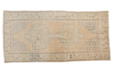 Vintage Distressed Oushak rug runner with double medallion, floral motifs, sand, and pale green.