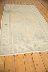 Distressed vintage Oushak runner with faded geometric medallions and visible abrashes.